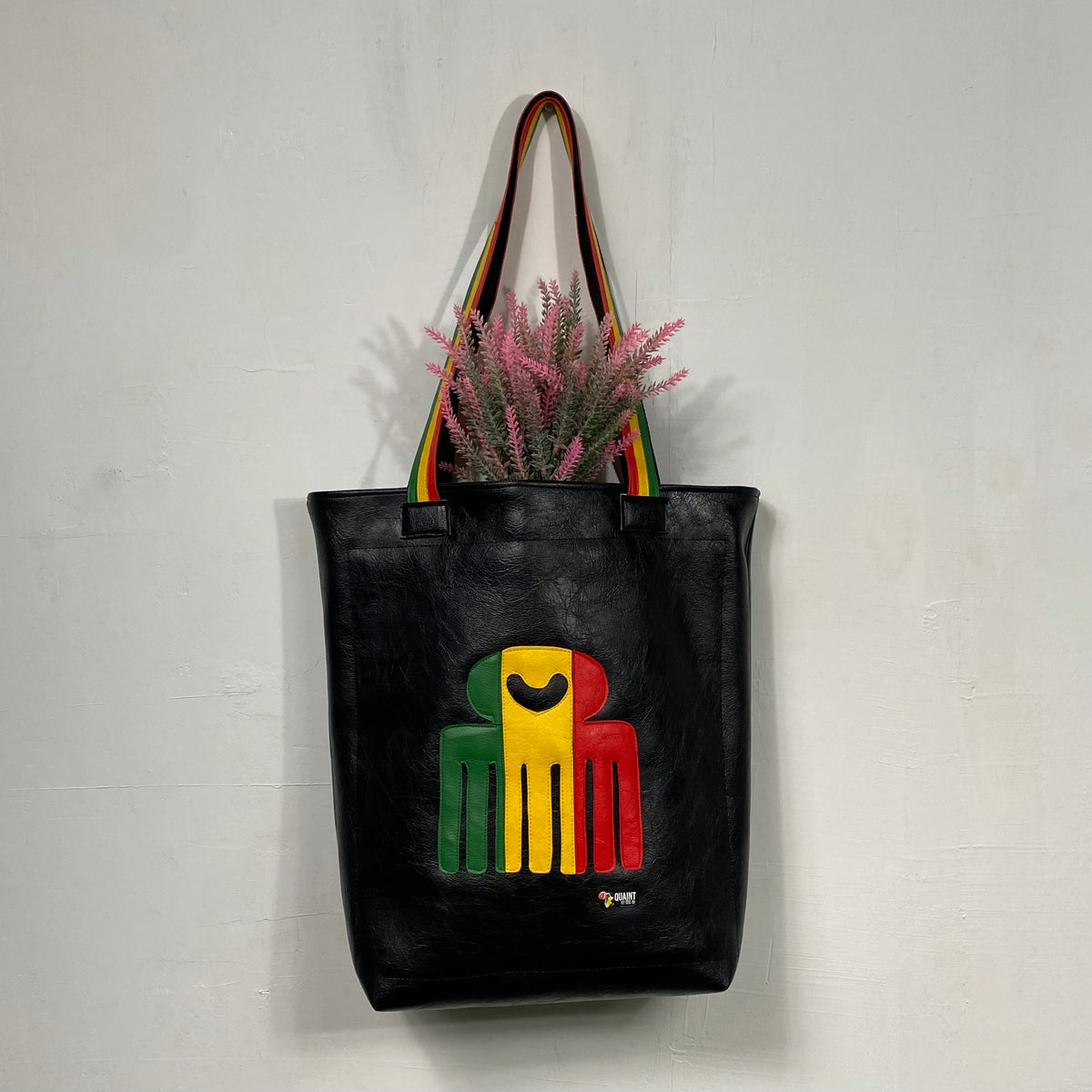 black leatherette tote bag with duafe adinkra symbol in rasta colors handmade in jamaica. laptop compartment, long straps and padded body. 