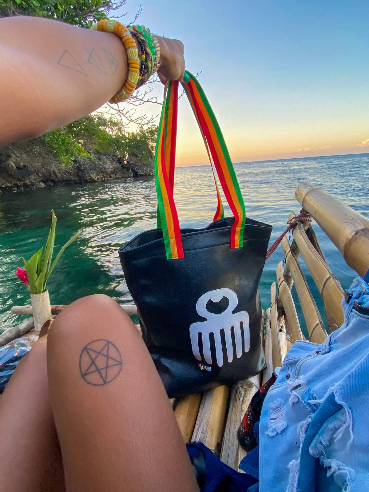 black leatherette tote bag with duafe adinkra symbol in rasta colors handmade in jamaica. laptop compartment, long straps and padded body. 